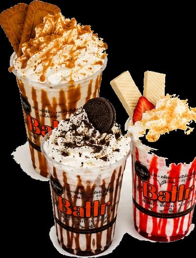 Three Battr gelato shakes topped with whipped cream, an Oreo, a strawberry and wafer cookies.
